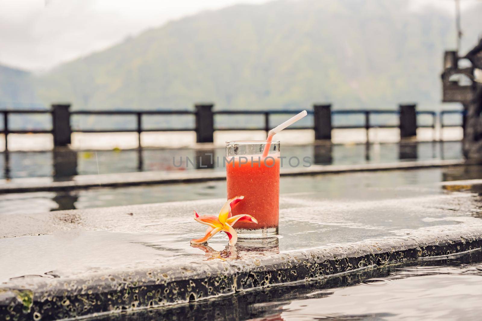 A glass of guava juice on the background of a lake and mountains. Healthy eating concept.