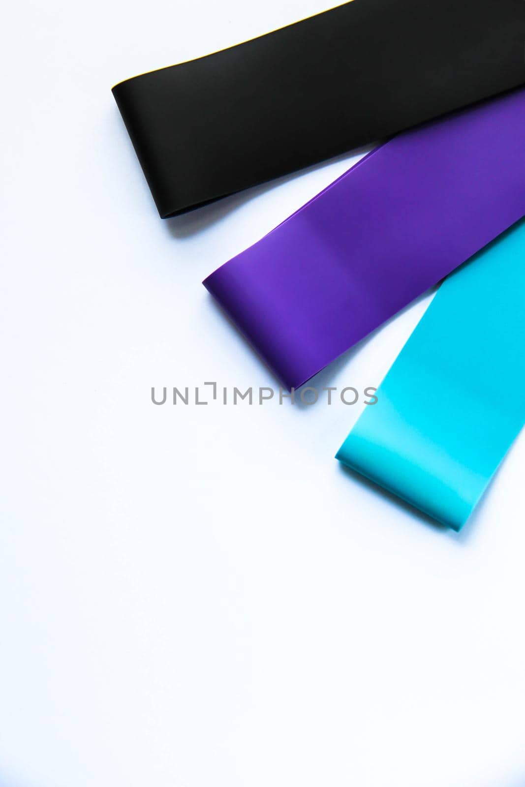 Fitness elastic band, elastic extenders of different colors for sports, isolated on a white background. Fitness trend by JuliaDorian