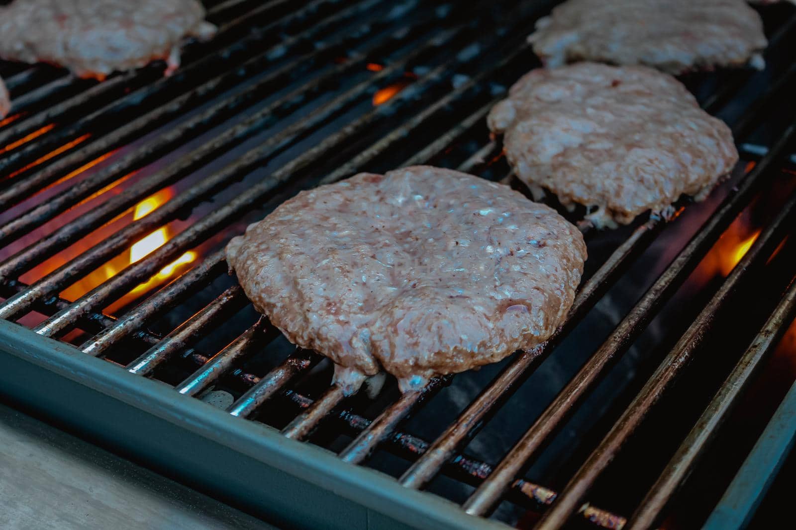 Smoky hamburger meat grilling on fire for burgers. BBQ Grilled Burgers Patties. by JuliaDorian