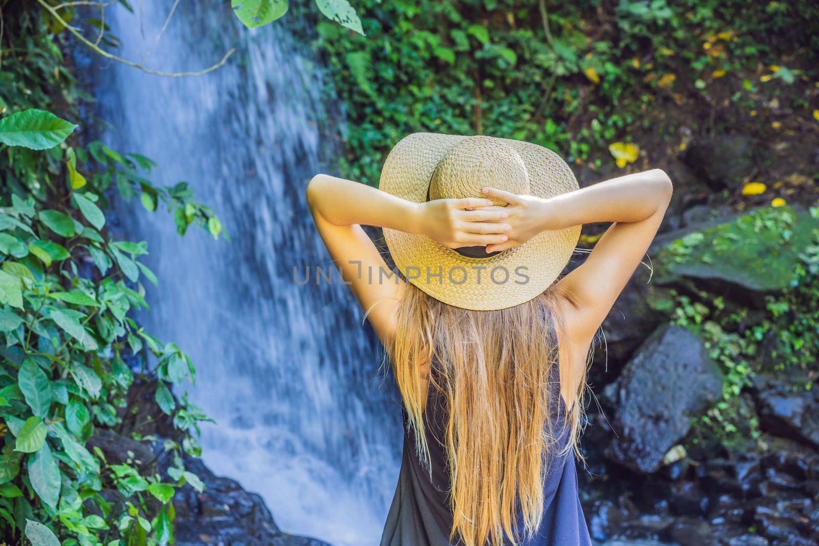 Woman traveler on a waterfall background. Ecotourism concept.