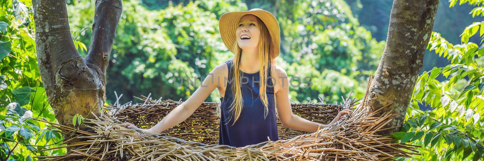 BANNER, LONG FORMAT Bali trend, straw nests everywhere. Young tourist enjoying her travel around Bali island, Indonesia. Making a stop on a beautiful hill. Photo in a straw nest, natural environment. Lifestyle by galitskaya