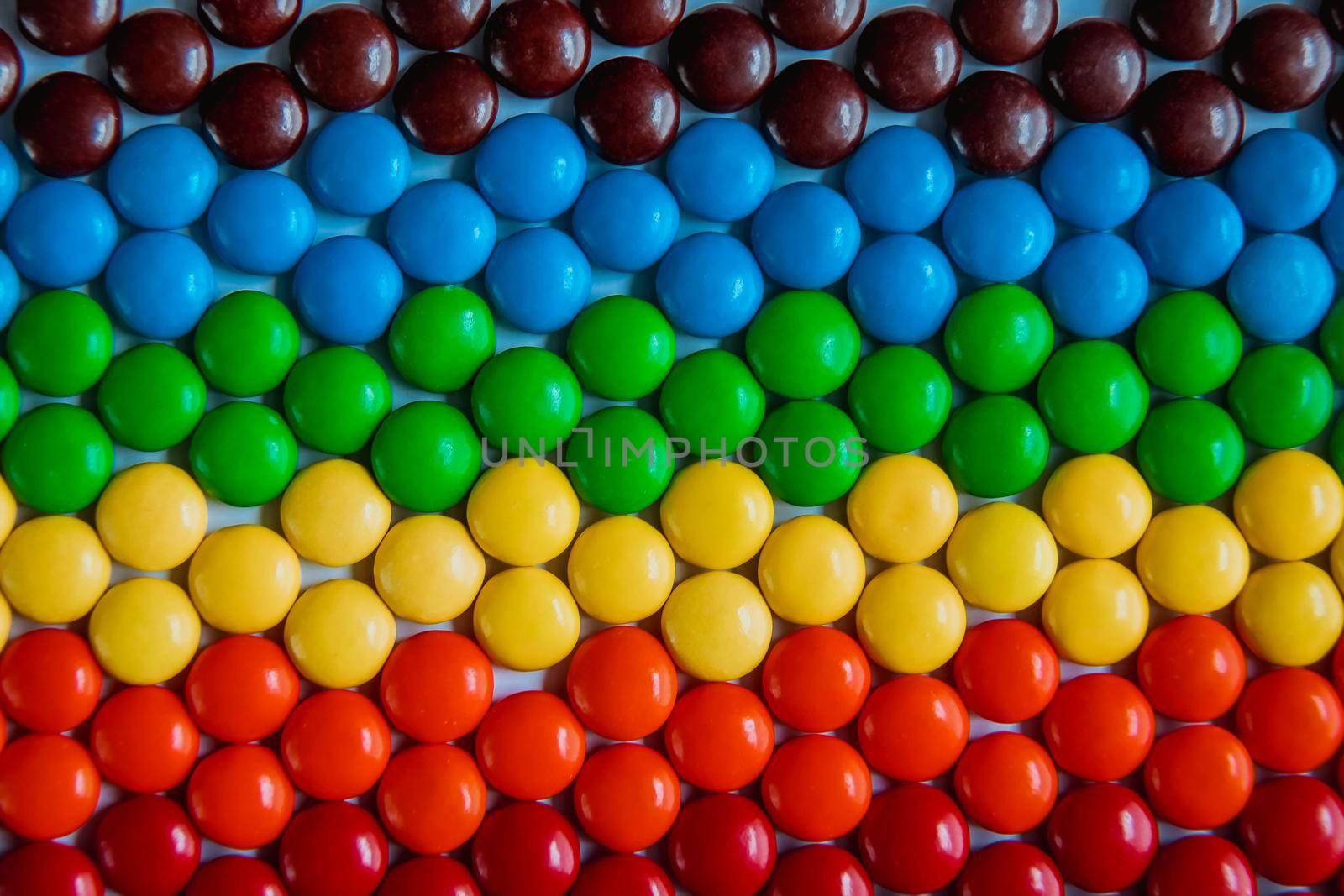 Brightly colored sweet candies laying flat. Rainbow candy background