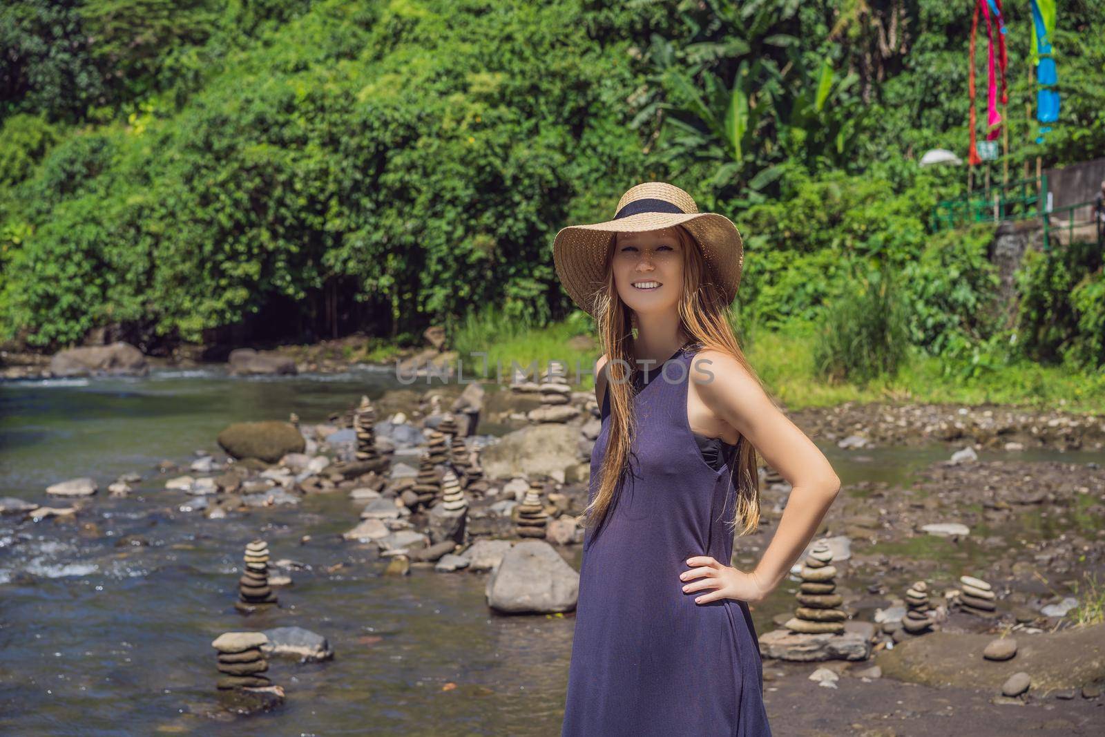 Tourist woman on background of Inuksuk Native Rock Pile in a Creek.