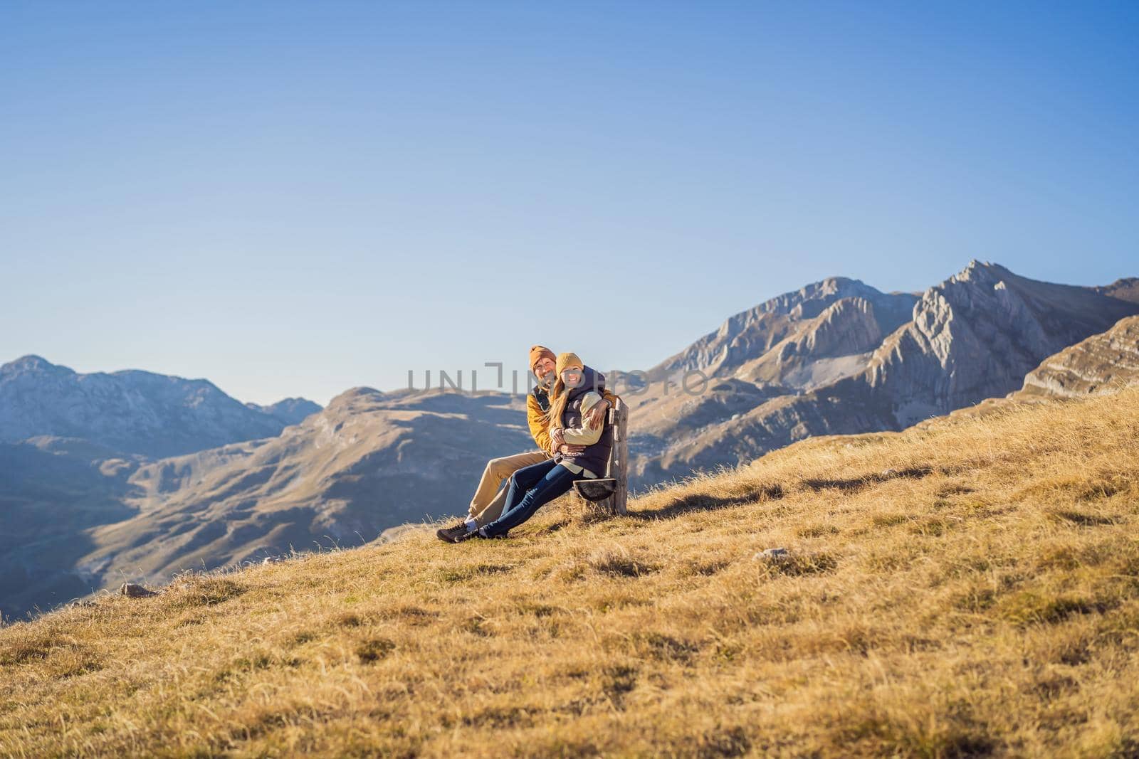 Montenegro. Happy couple woman and man tourists in the background of Durmitor National Park. Saddle Pass. Alpine meadows. Mountain landscape. Travel around Montenegro concept.