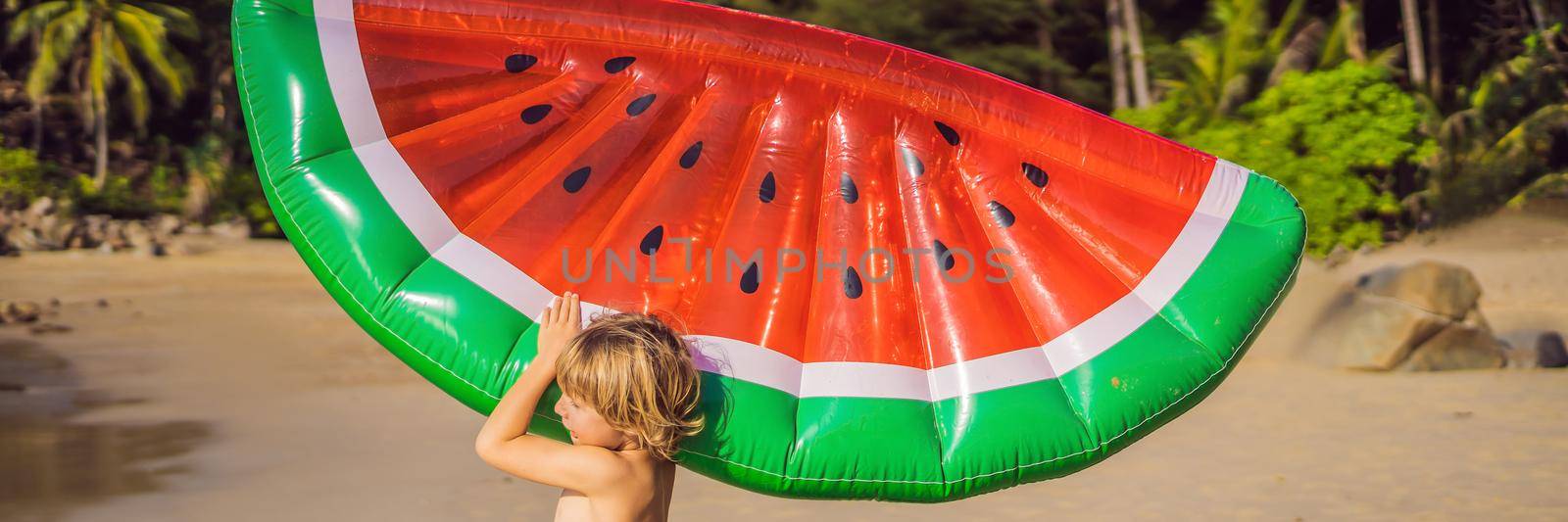The boy goes to sea with an inflatable mattress. BANNER, LONG FORMAT