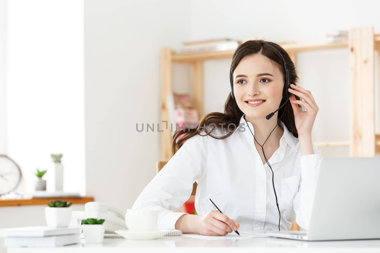 Call Center Concept: Portrait of happy smiling female customer support phone operator at workplace. by Benzoix