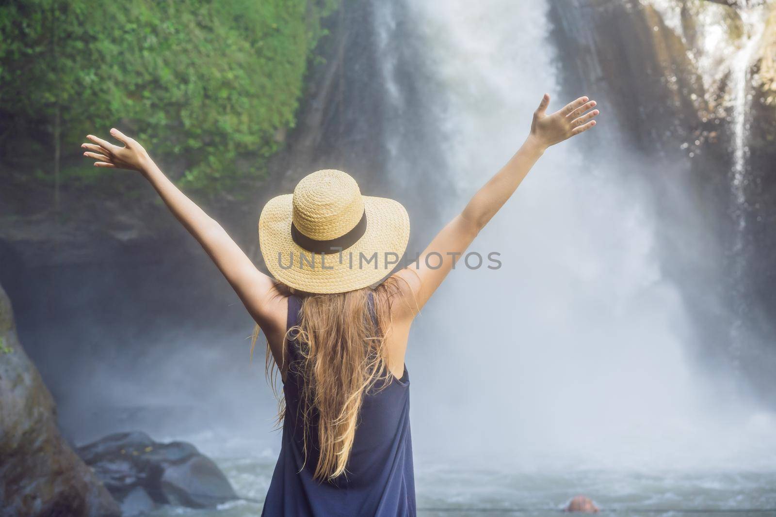 Woman traveler on a waterfall background. Ecotourism concept.