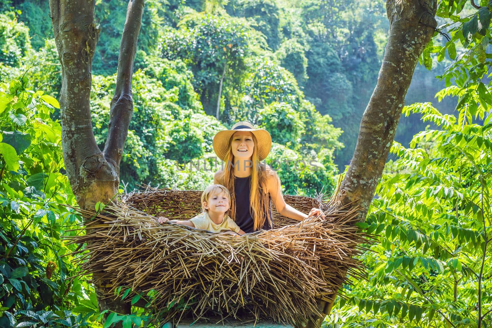 Bali trend, straw nests everywhere. Young tourist enjoying her travel around Bali island, Indonesia. Making a stop on a beautiful hill. Photo in a straw nest, natural environment. Lifestyle.
