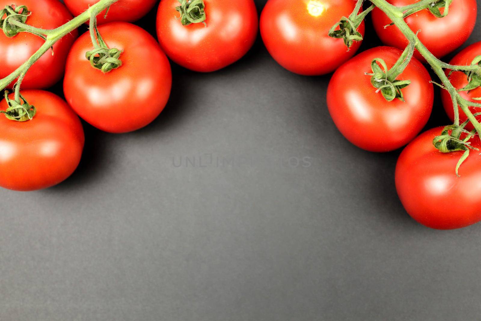 Red tomatoes on white plate with water drops