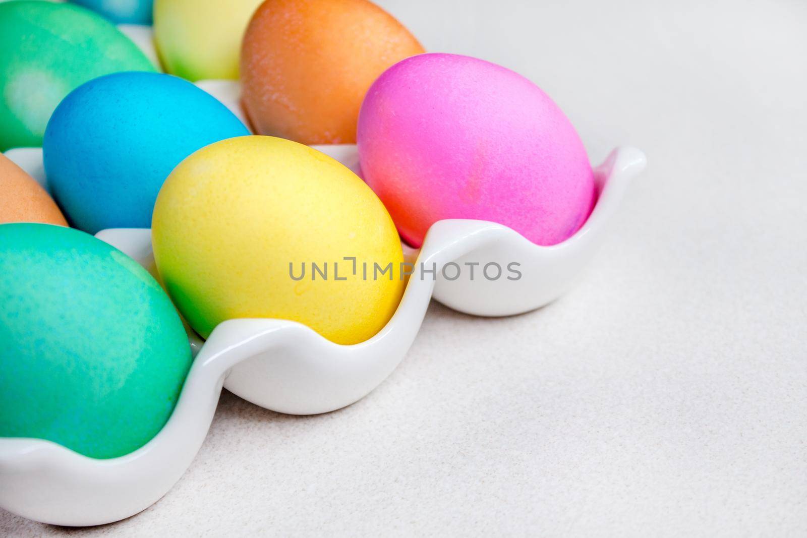 Pastel Easter eggs lying on white table. Traditional decoration