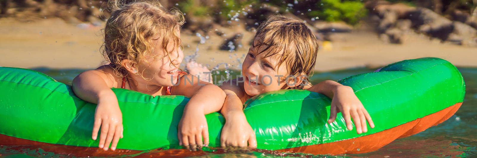 Children swim in the sea on an inflatable mattress and have fun BANNER, LONG FORMAT by galitskaya