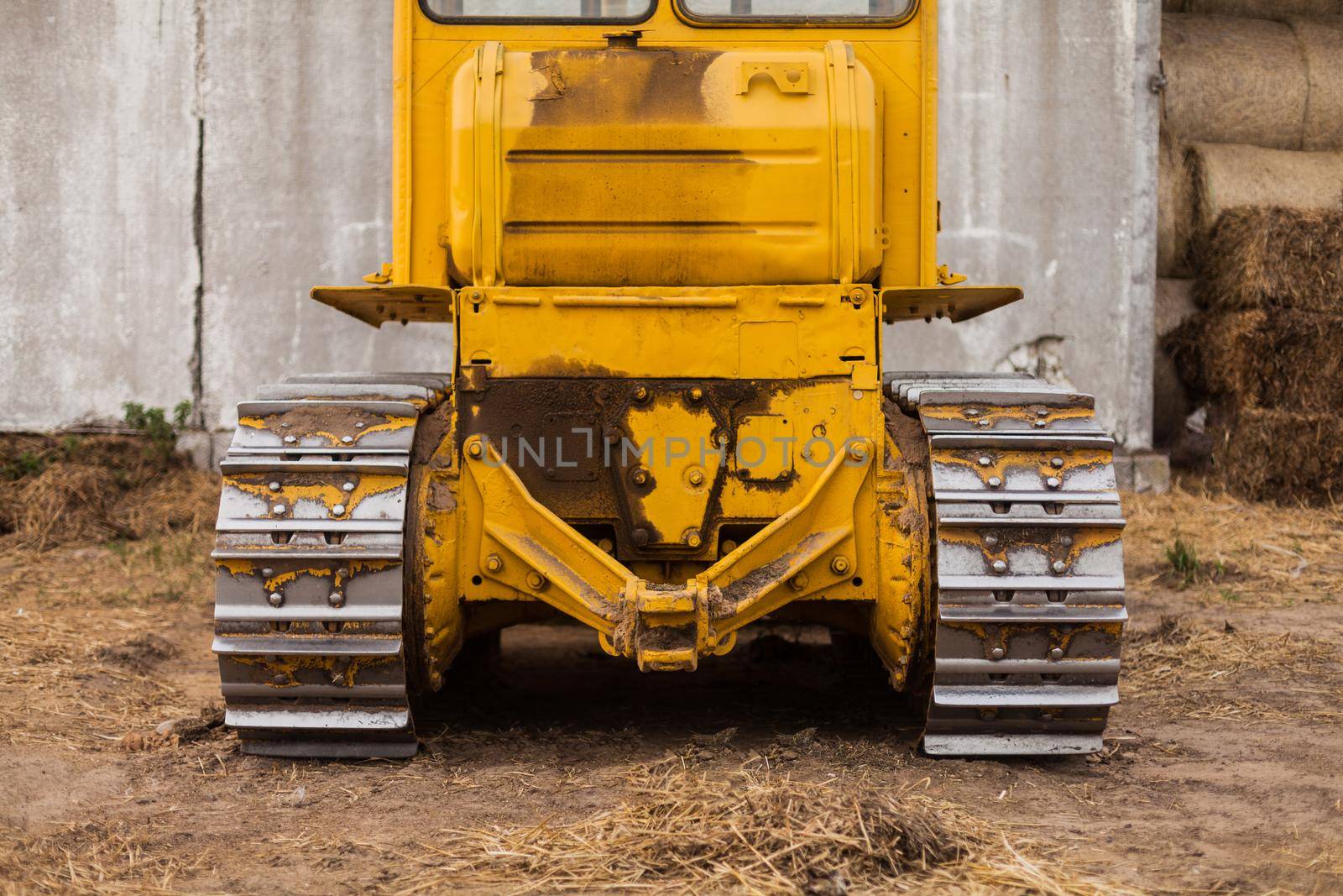 Close-up of crawler bulldozer truck. Earthmoving heavy machinery. Yellow crawler machinery. Yellow Tractor on caterpillar tracks, tractor tracks