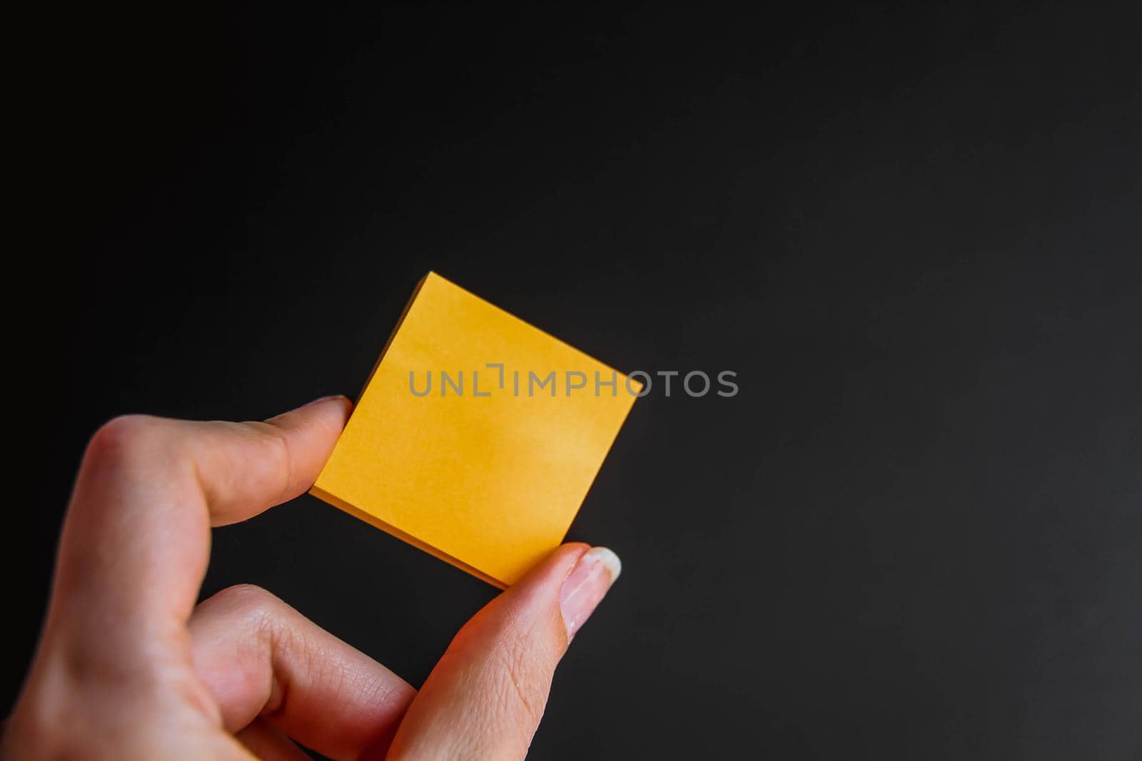 Hand with colorful yellow notes on black background by JuliaDorian