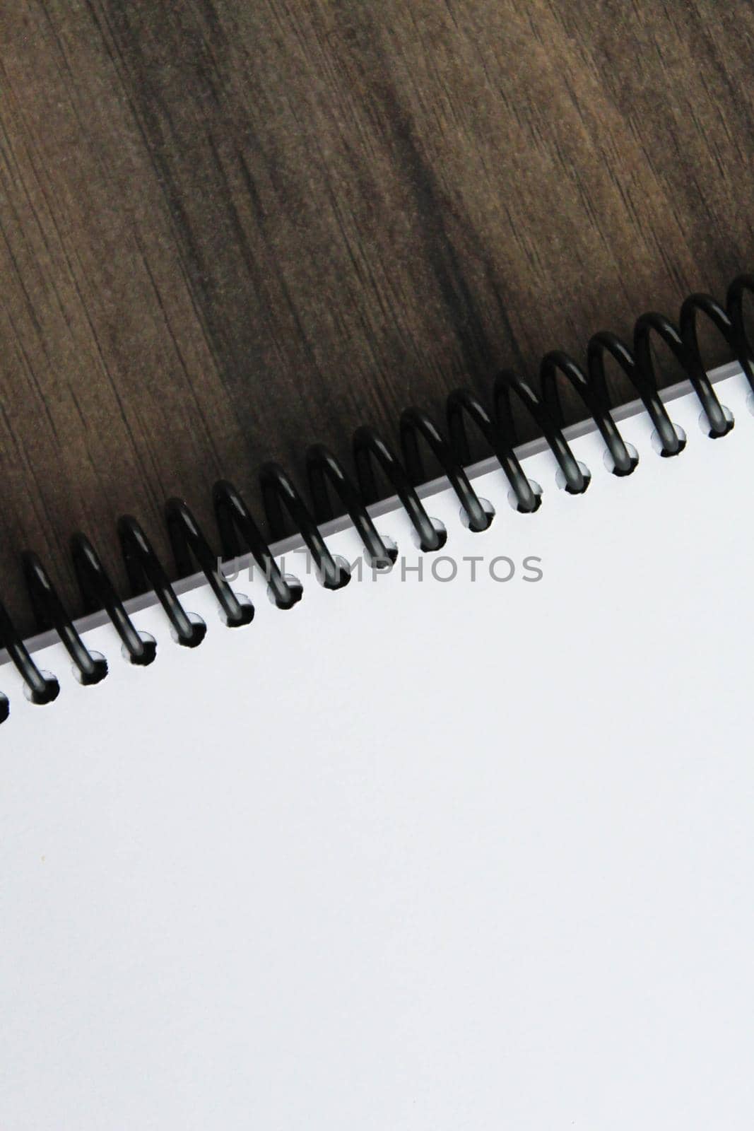 Spiral notepad paper on the wooden background. Vertical and space for text