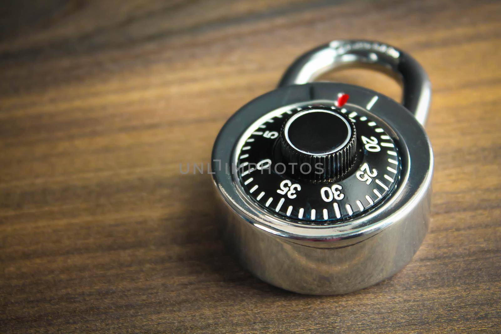 Combination lock on the wooden background