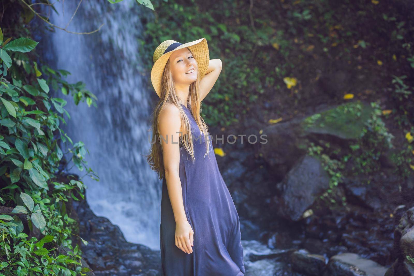 Woman traveler on a waterfall background. Ecotourism concept.