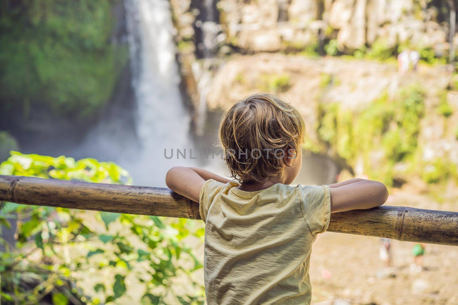 Boy traveler on a waterfall background. Ecotourism concept. Traveling with kids concept. What to do with children. Child friendly place.