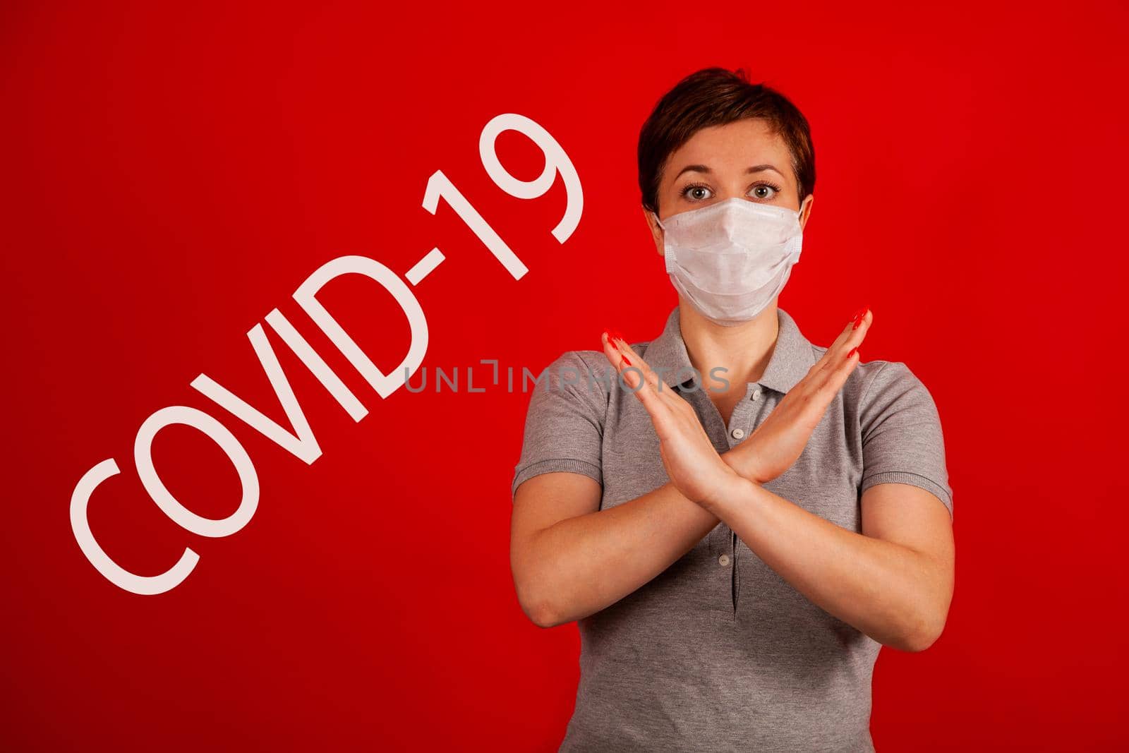 A woman in a mask indicates stopping the spread of the COVID-19 virus. The concept of preventing the spread of the epidemic and treating coronavirus. Coronavirus treatment.