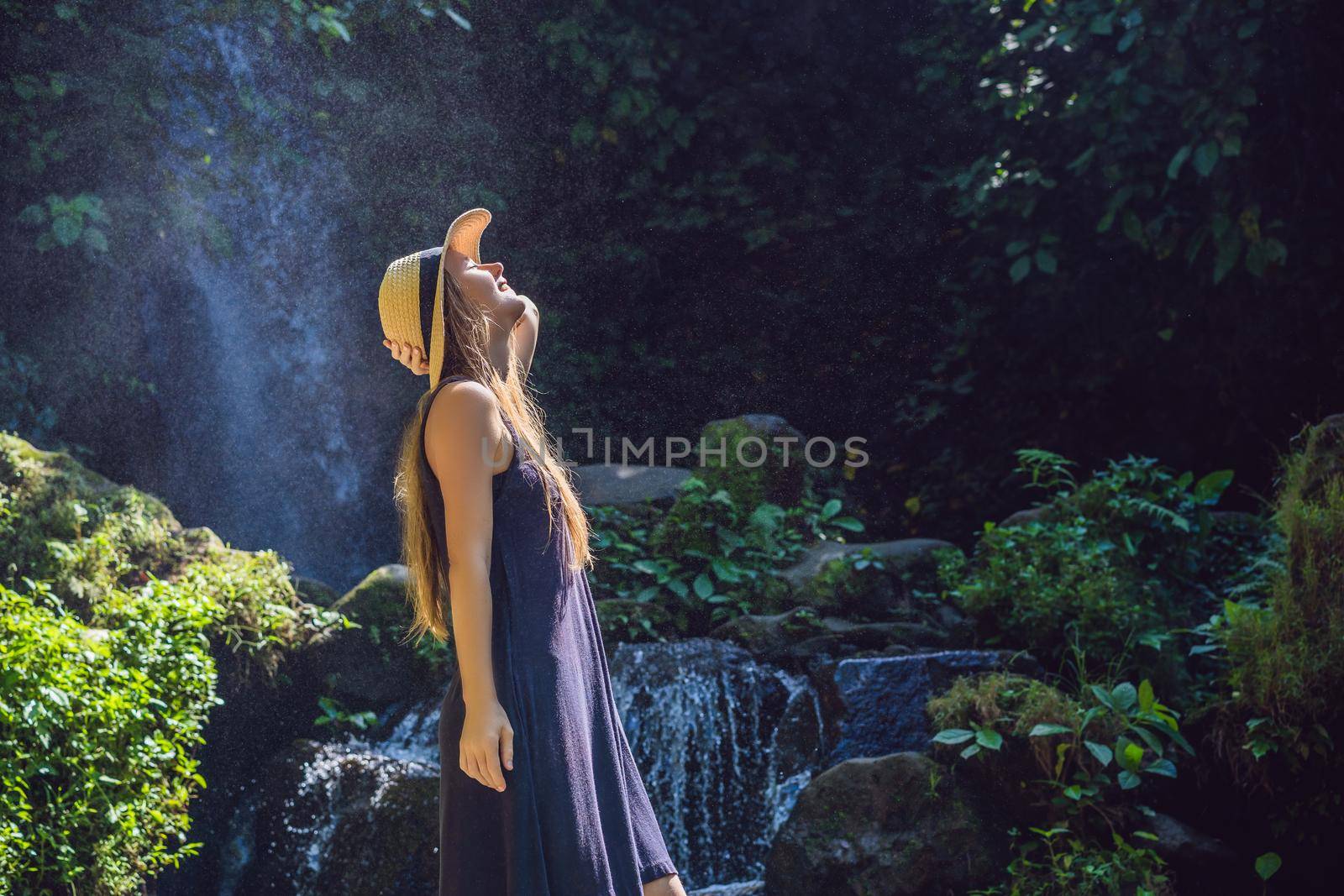 Woman traveler on a waterfall background. Ecotourism concept.