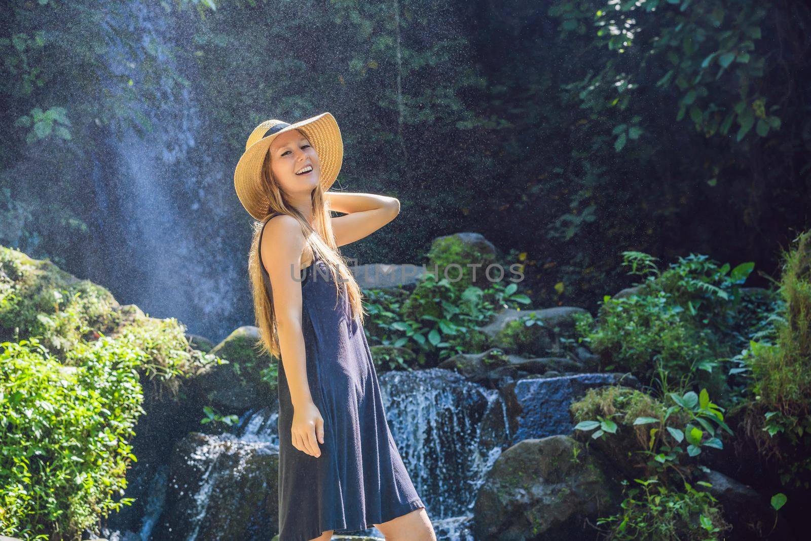 Woman traveler on a waterfall background. Ecotourism concept.