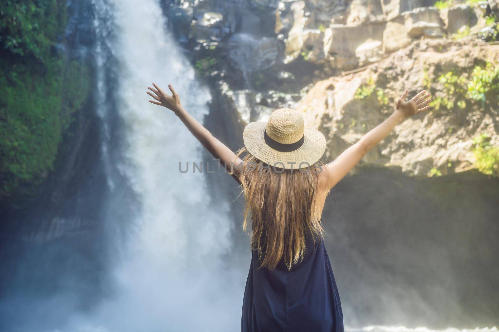 Woman traveler on a waterfall background. Ecotourism concept.