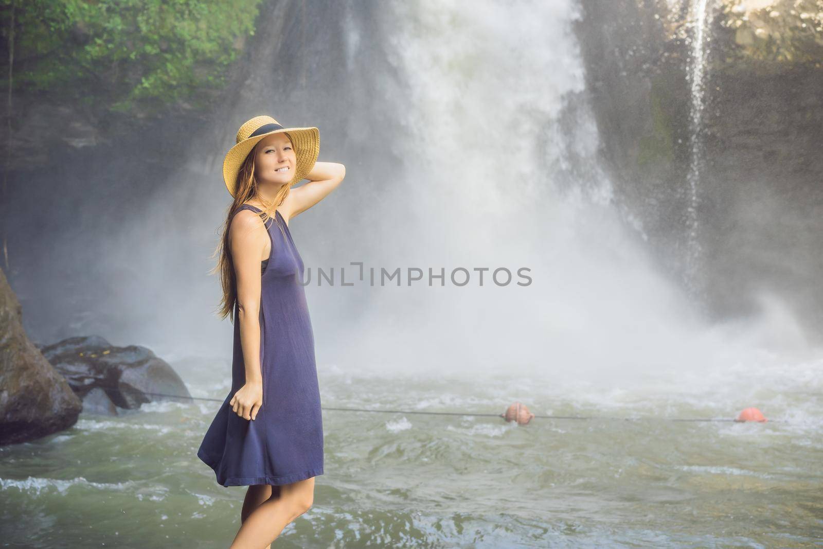 Woman traveler on a waterfall background. Ecotourism concept.