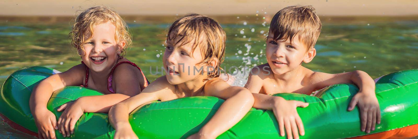 Children swim in the sea on an inflatable mattress and have fun BANNER, LONG FORMAT by galitskaya