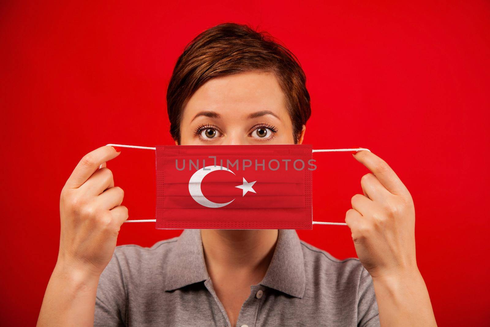 Coronavirus COVID-19 in Turkey. Woman in medical protective mask with the image of the flag of Turkey. The concept of preventing the spread of the epidemic and treating coronavirus.
