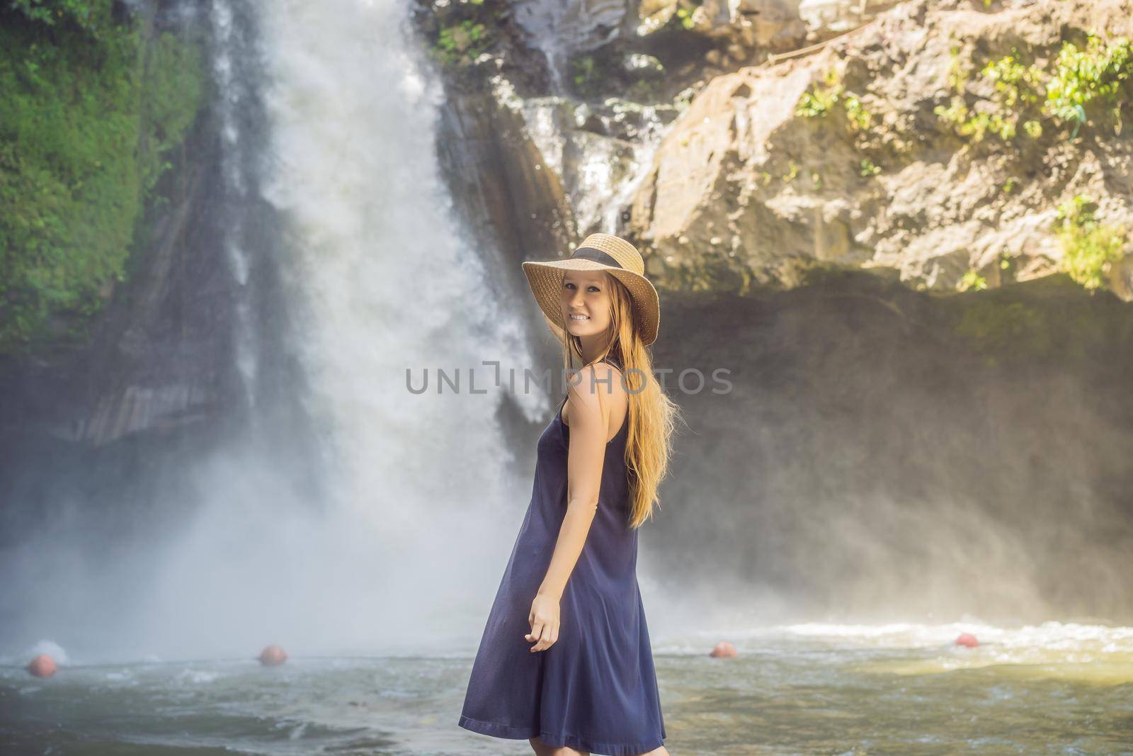 Woman traveler on a waterfall background. Ecotourism concept.