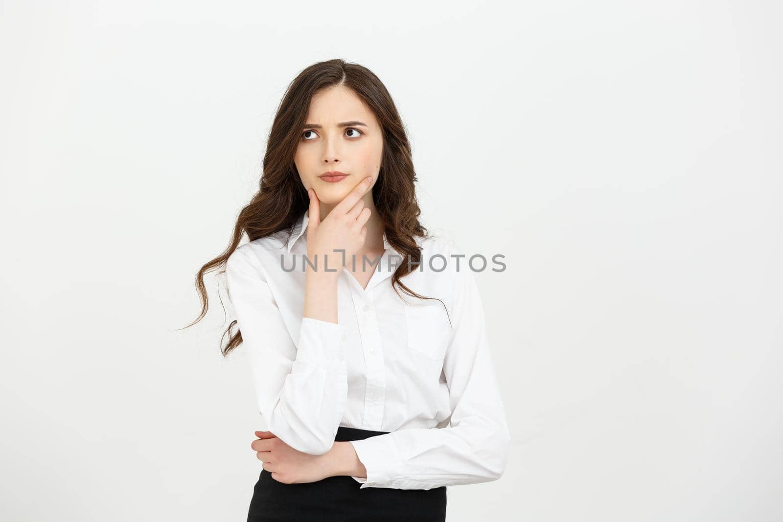 Business Concept: Thoughtful businesswoman with a finger under chin looking. Isolate on white background