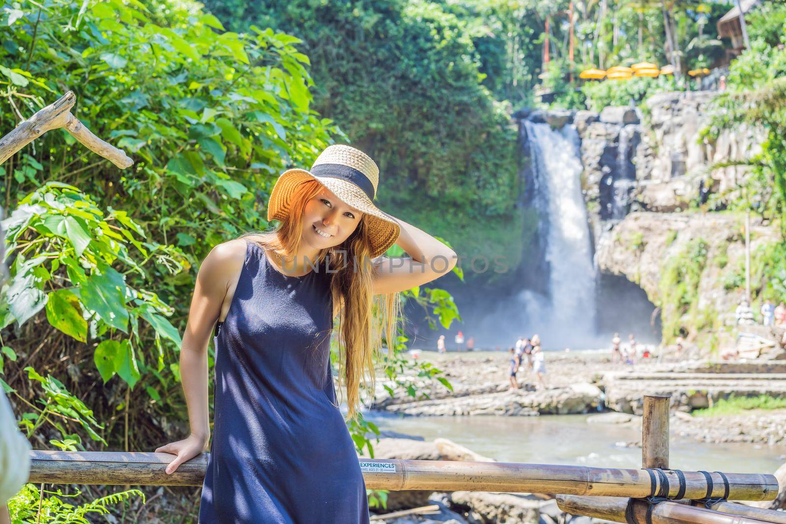 Woman traveler on a waterfall background. Ecotourism concept.