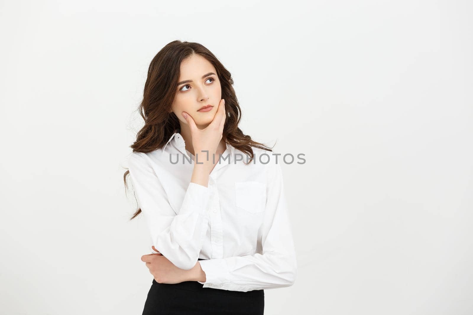 Business Concept: Thoughtful businesswoman with a finger under chin looking. Isolate on white background