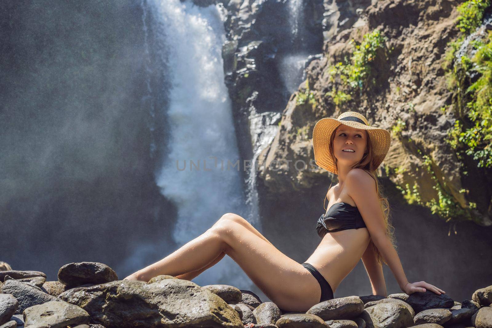 Woman traveler on a waterfall background. Ecotourism concept.