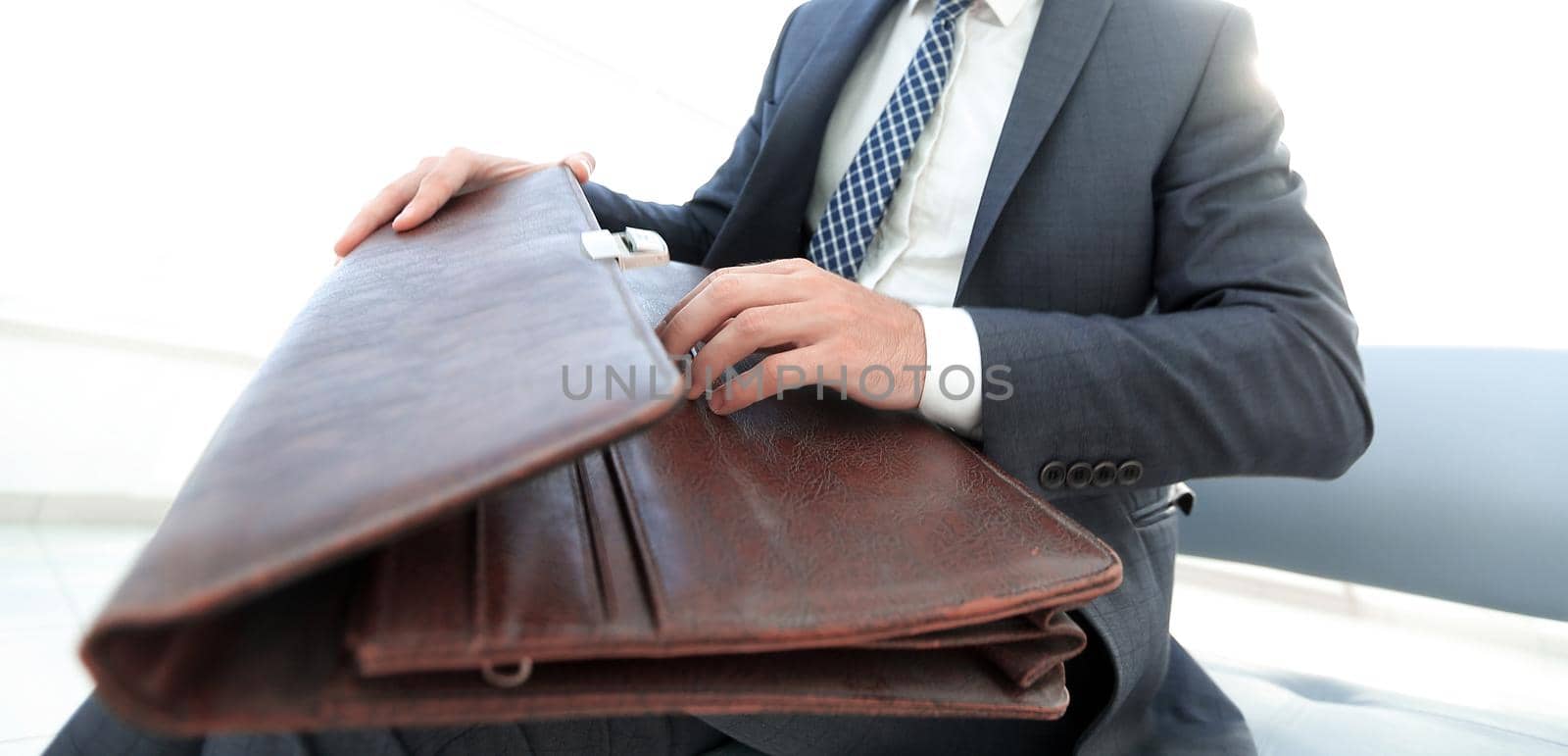 Businessman holding a briefcase in a modern office