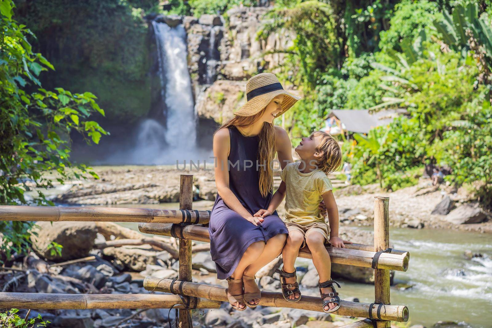 Mom and son tourists on the background of a waterfall. Traveling with kids concept. What to do with children Children friendly place by galitskaya