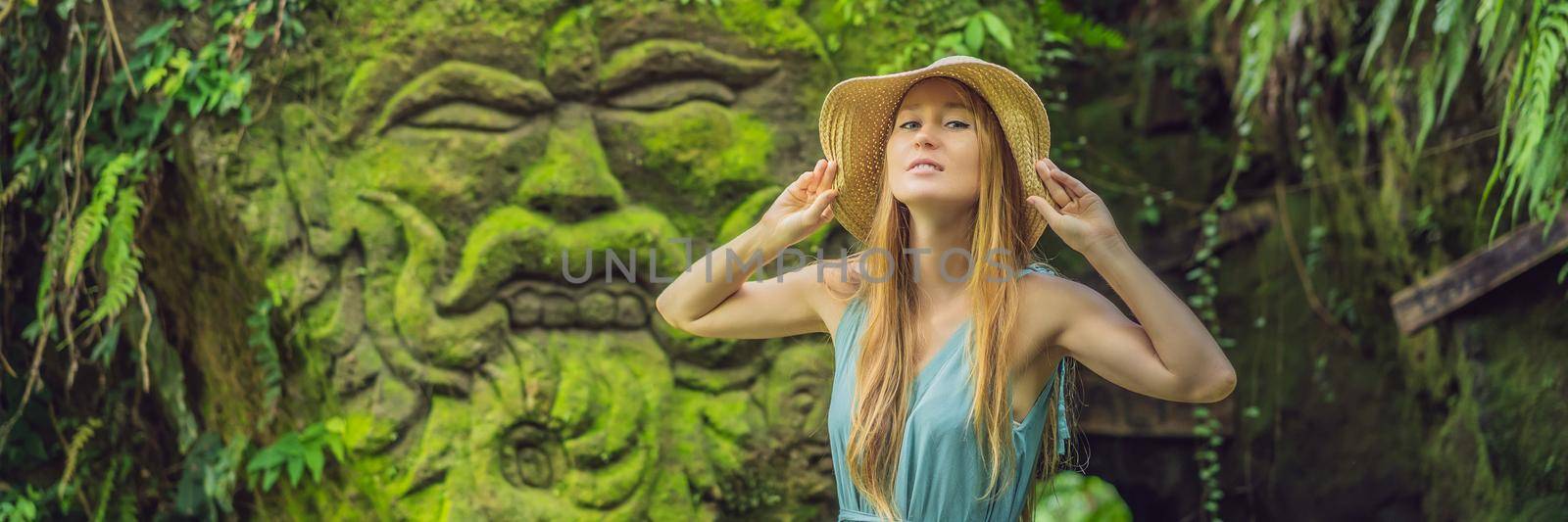 Young woman traveler in a Balinese garden overgrown with moss. Travel to Bali concept. BANNER, LONG FORMAT