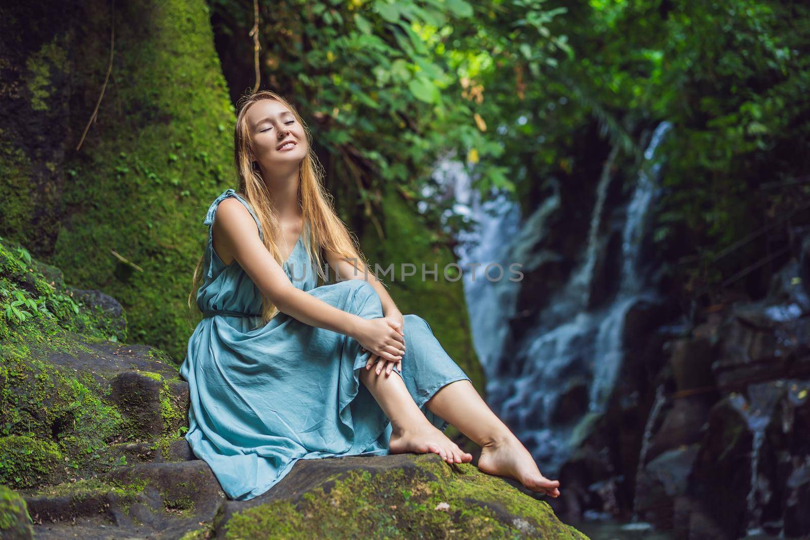 Woman traveler on a waterfall background. Ecotourism concept.