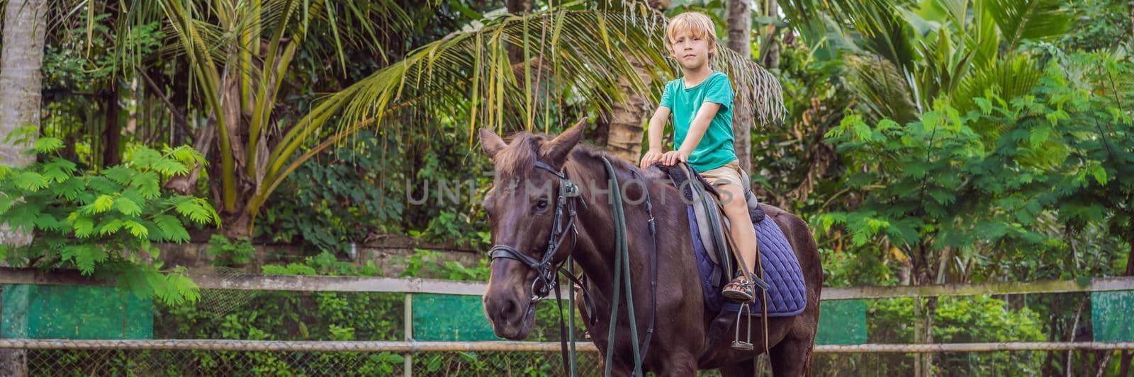 Boy horseback riding, performing exercises on horseback BANNER, LONG FORMAT by galitskaya