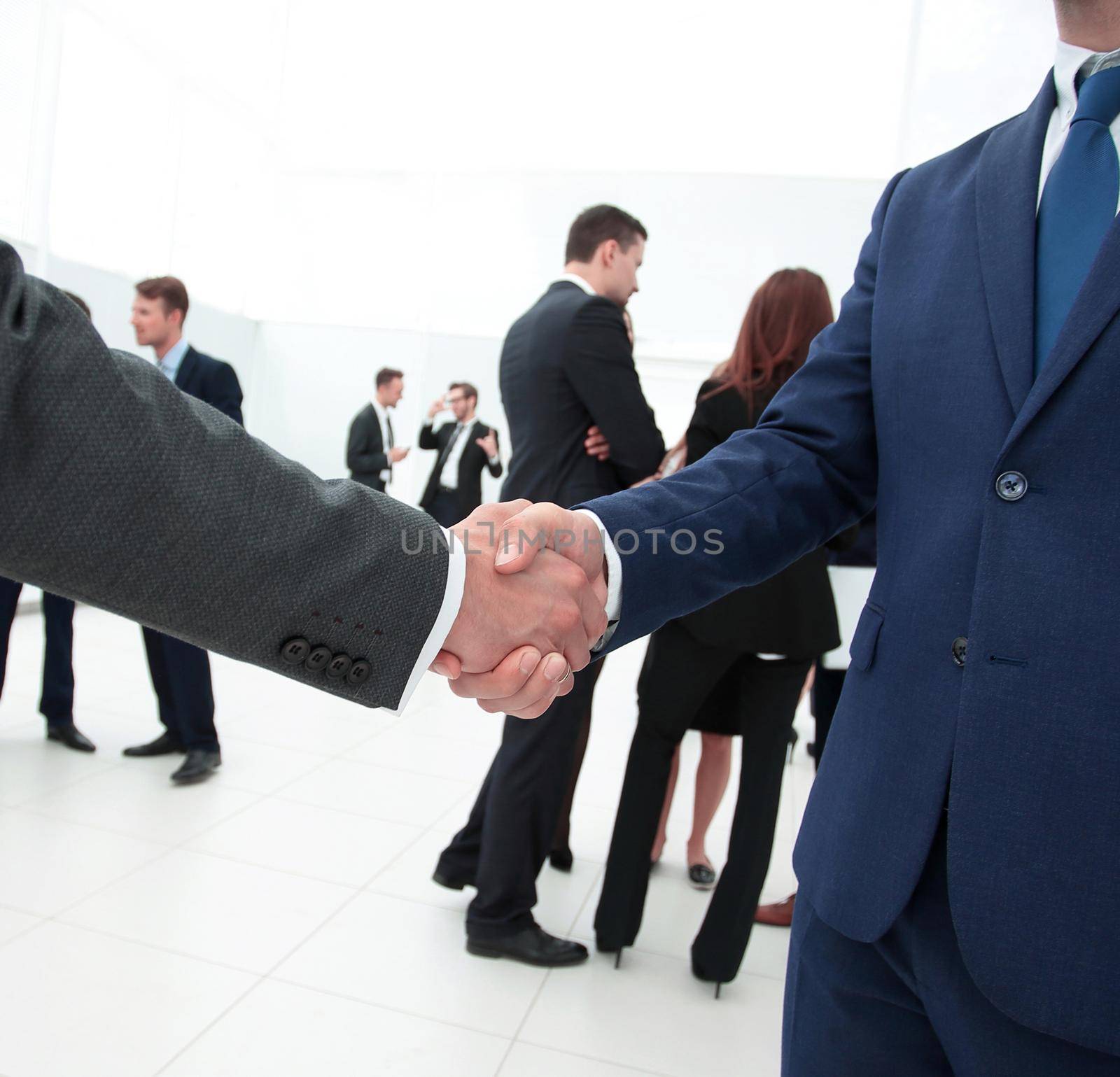 business concept.closeup of handshake of business partners on the background of business team
