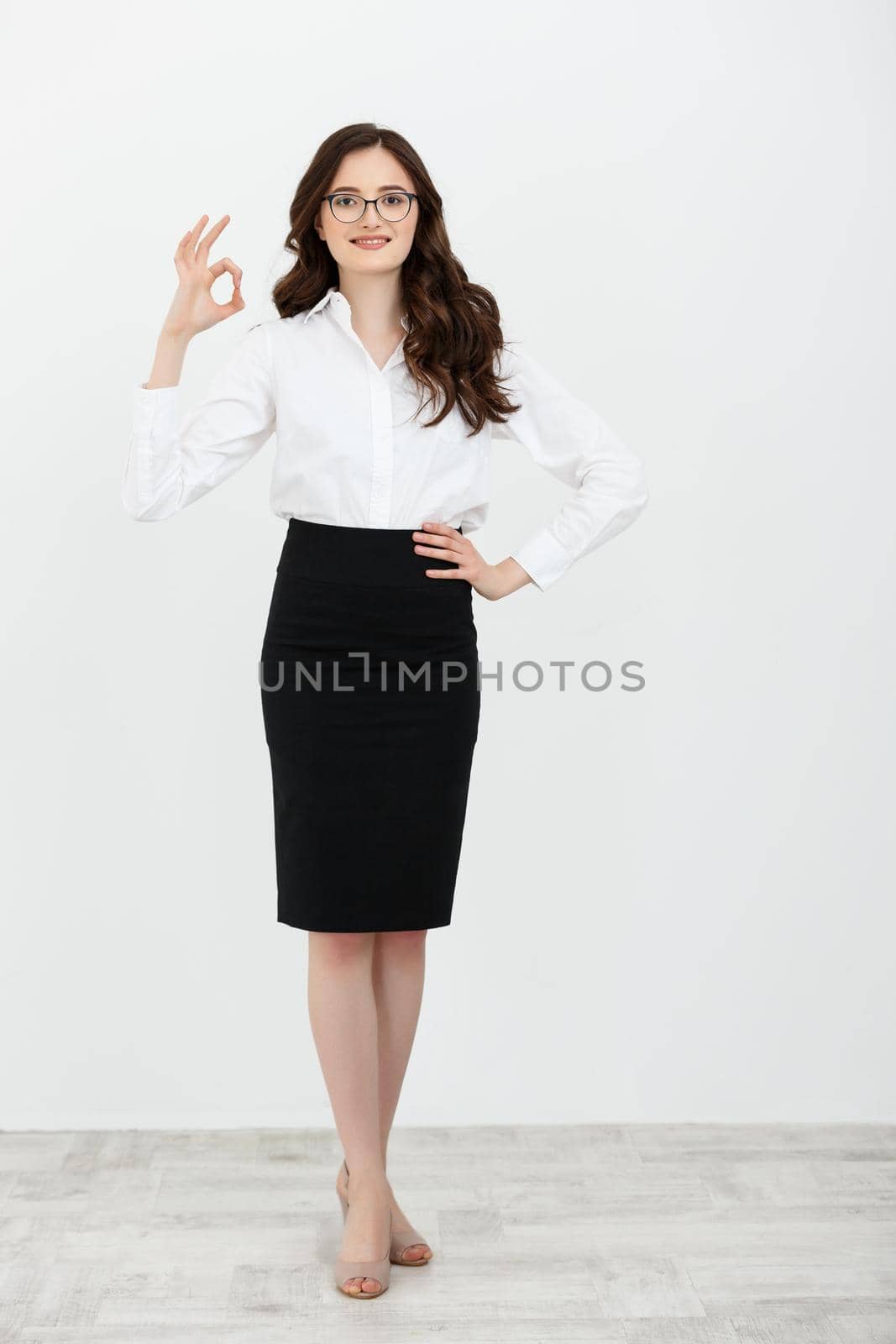 Portrait of Business woman holding ok finger sign isolated on plain white background in studio