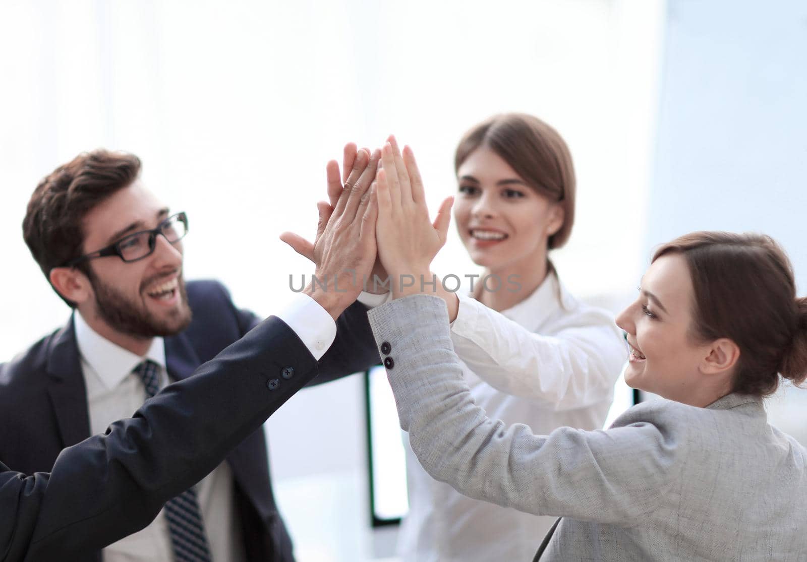 successful business team giving each other a high-five, standing in the office.concept of success.