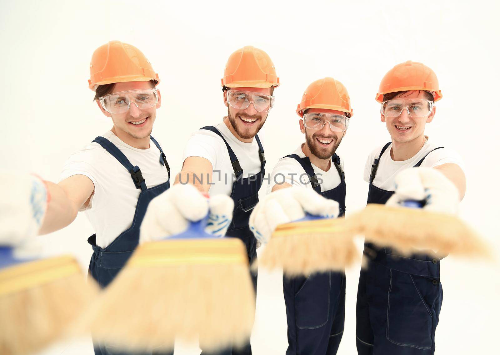 closeup.smiling group of builders with a paint brush.isolated on white.