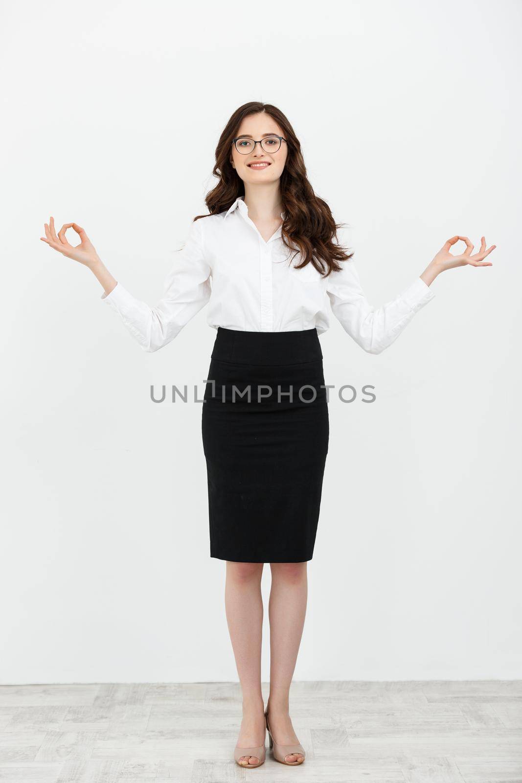 Full length portrait business woman doing stand relaxing yoga isolated on plain white background.