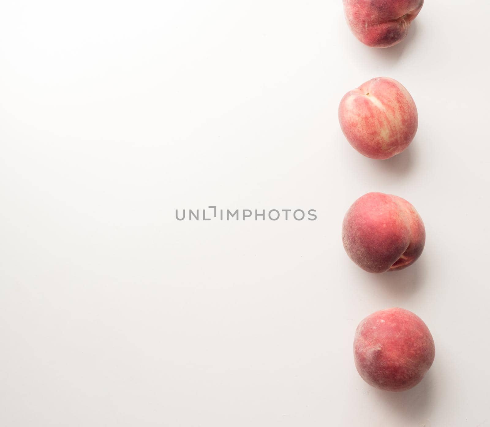High angle view of white peaches arranged in a column on table with copy space to left