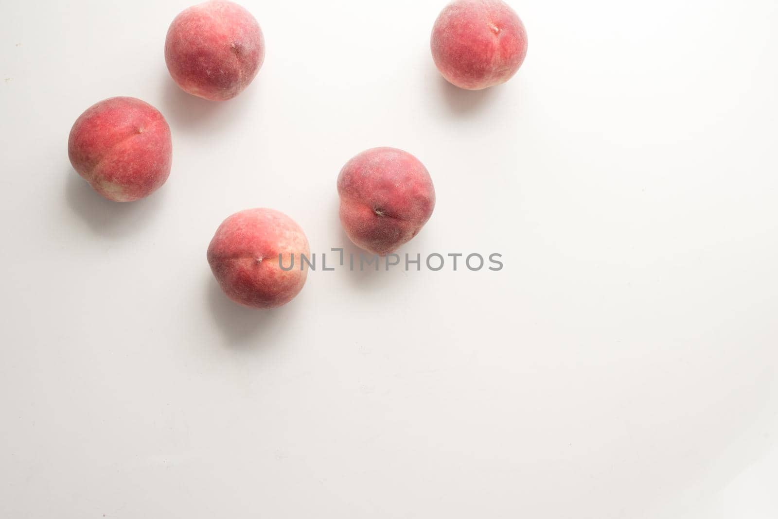 High angle view of five white peaches scattered on table by natalie_board