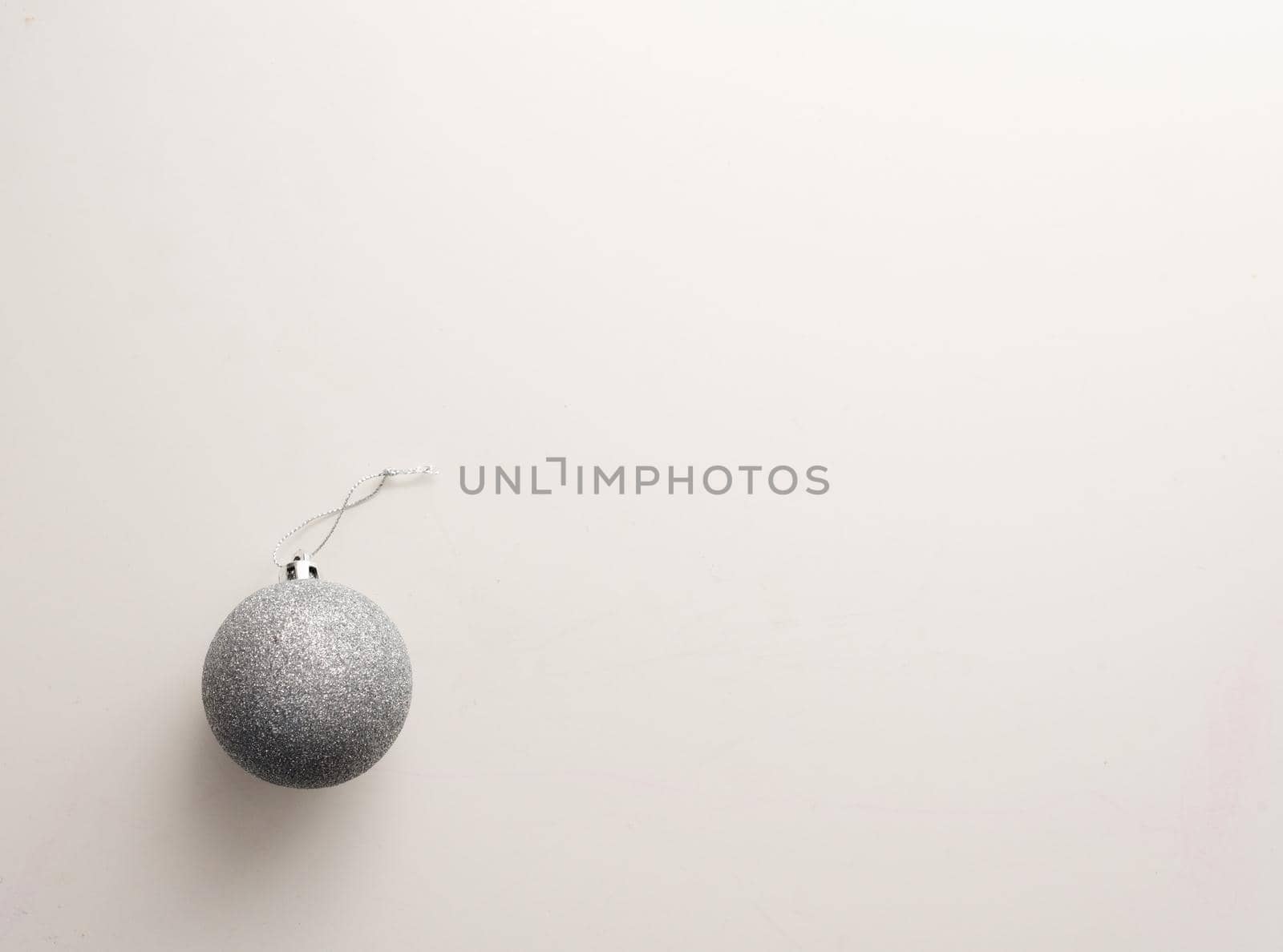 High angle view of silver christmas tree ball on white table (selective focus)