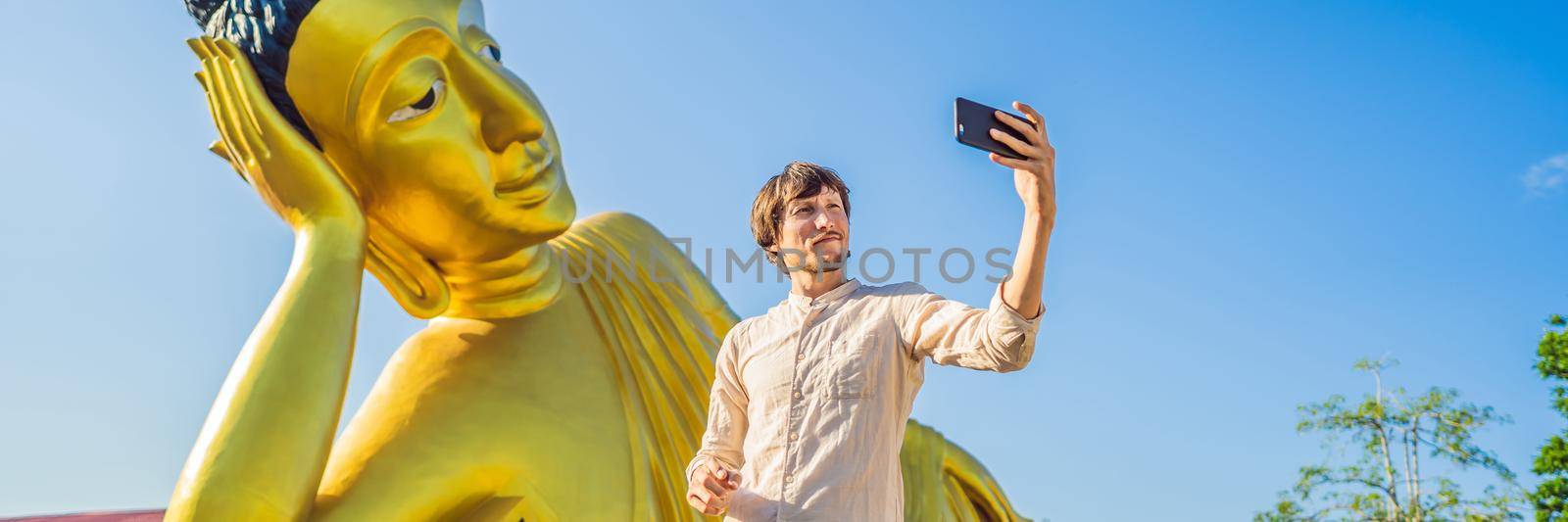 Happy man tourist on background ofLying Buddha statue. BANNER, LONG FORMAT