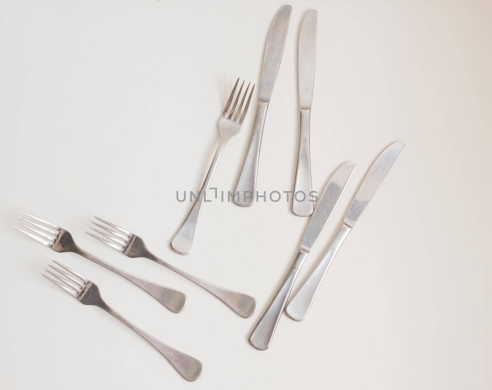 Food background - high angle view of four forks and knives on white table