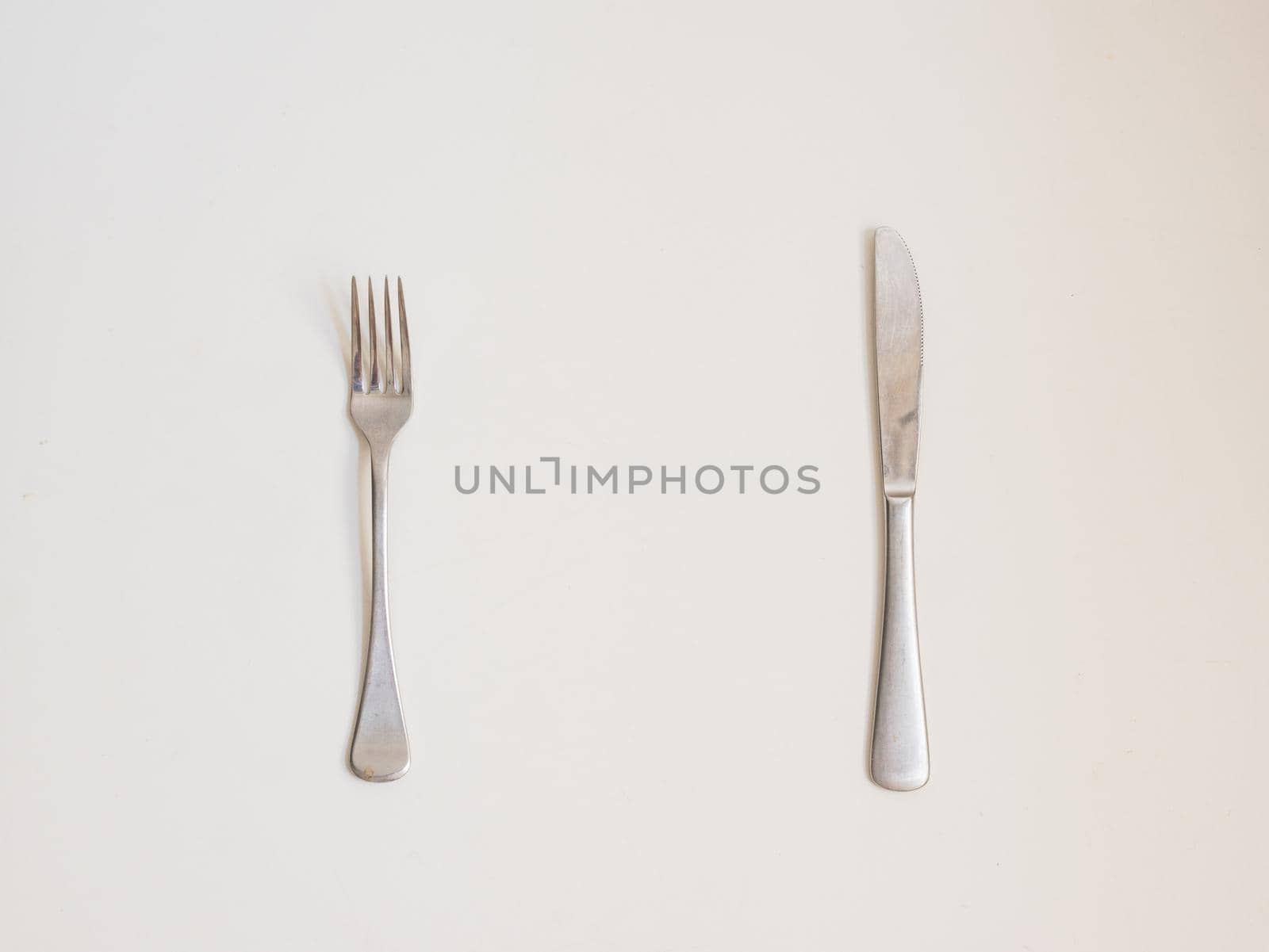 Food background - high angle view of fork and knife on white table by natalie_board