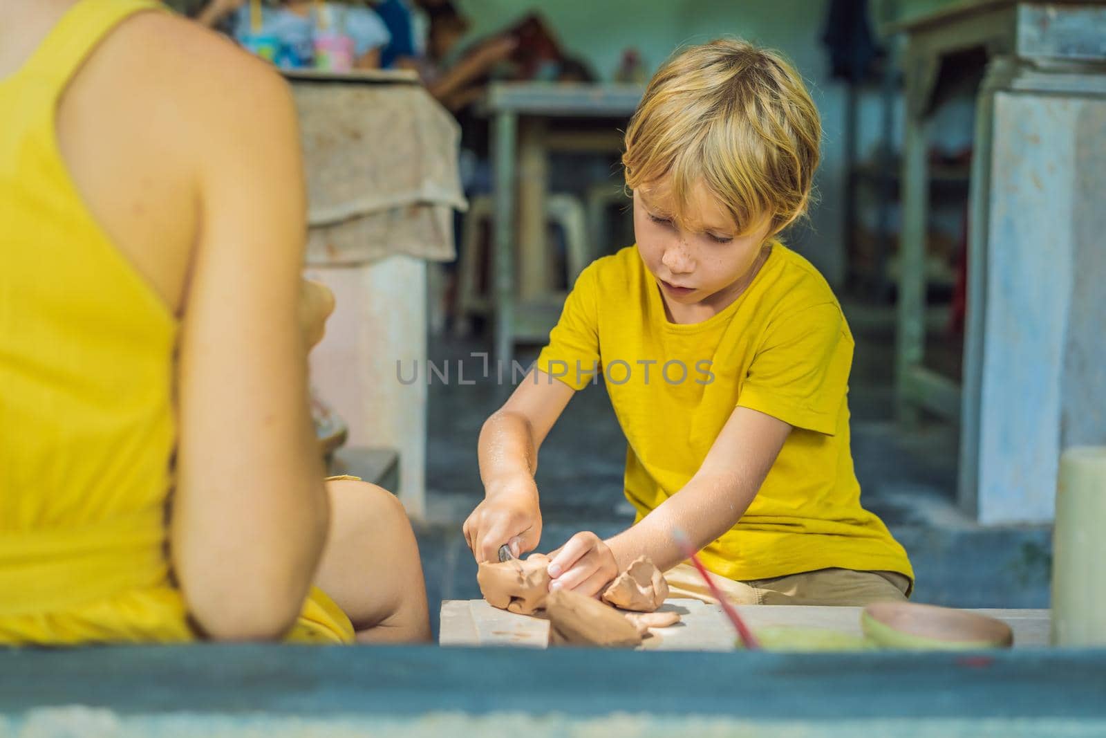 mother and son doing ceramic pot in pottery workshop. What to do with children. Child friendly place by galitskaya